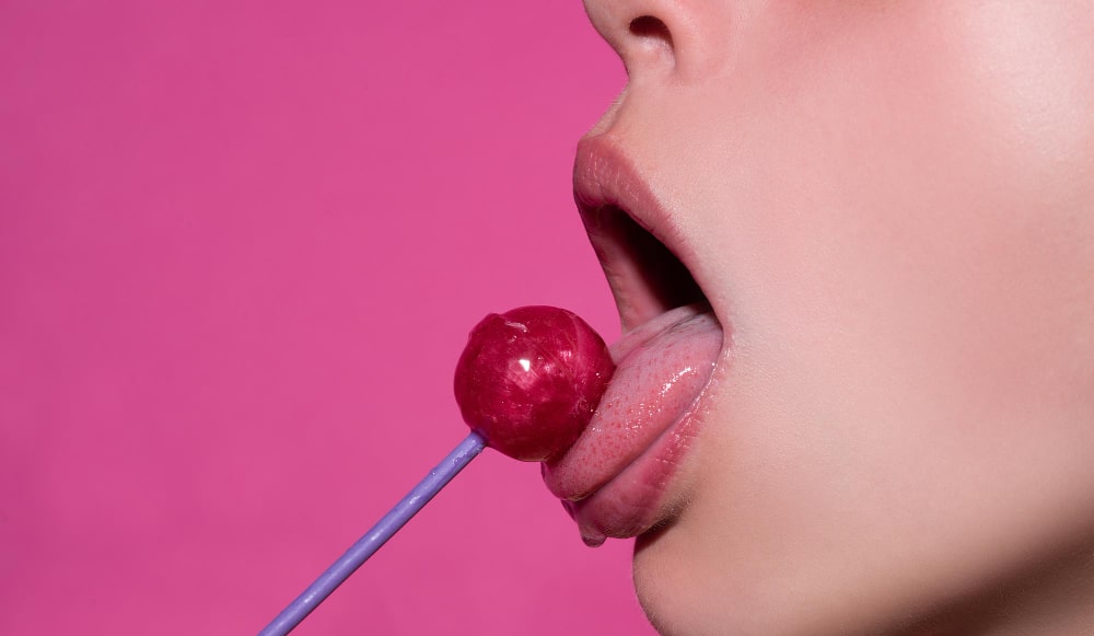 mouth-licking-lollipop-red-female-glossy-lips-pink-candy-lollipop-isolated-pink-min